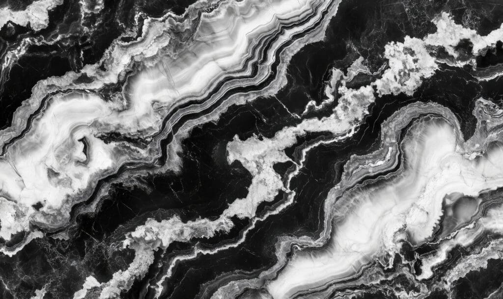 Black and white marble texture with wavy, layered patterns. Perfect for bespoke bathrooms, its dramatic veining and cloud-like shapes create a striking, abstract design inspired by natural stone. Ideal for standout bathroom installations.